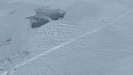 Drone-flight-over-a-frozen-lake-while-revealing-trees-of-the-forest