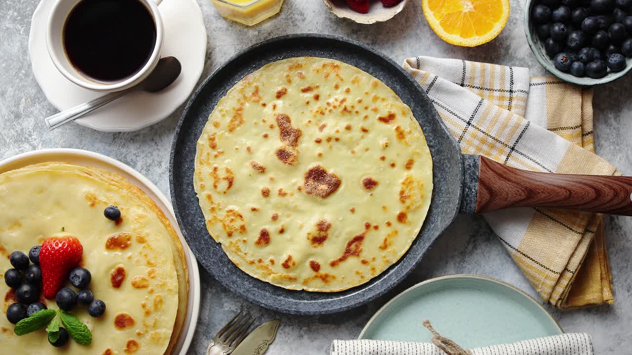 deliciosos panqueques en sartén de piedra colocados en la mesa con varios ingredientes