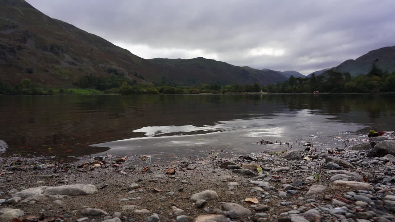 tiro deslizante de la playa de guijarros y las tranquilas orillas del lago ullswater en el distrito de los lagos, cumbria, inglaterra, reino unido