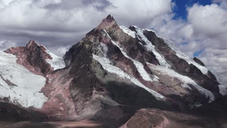 aerial view of one of the 7 lagoons of ausangate in cusco, peru, with snow-capped mountains, establishing pan