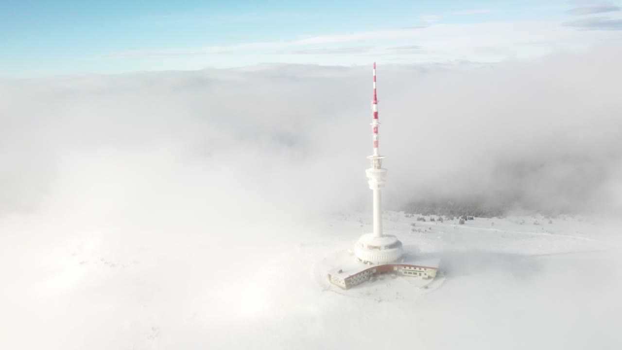 Transmission And Lookout Tower Shrouded By Fog And Clouds During Winter In The Peak Of Praded Mountain In Czech Republic. - aerial shot