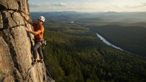 a determined climber skillfully ascends a rugged rock face surrounded by breathtaking vistas of mountains and forests, showcasing the beauty of outdoor adventure in nature.