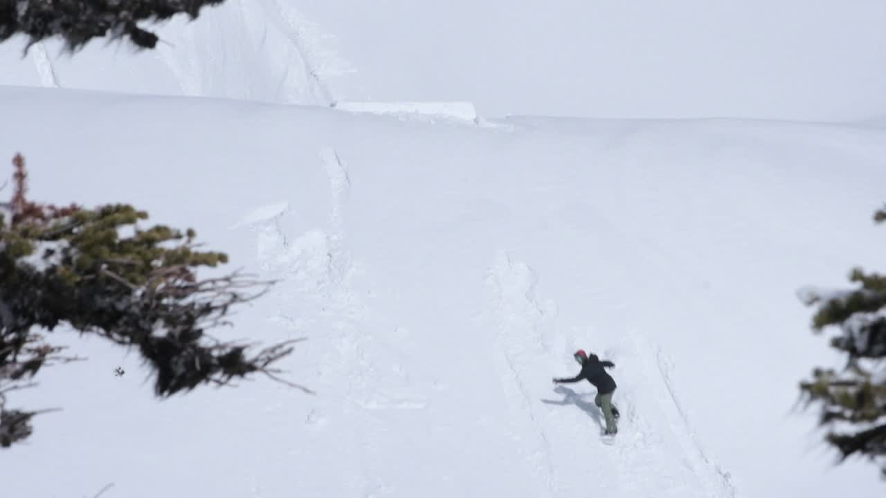 snowboarder haciendo un backflip con un agarre sobre un salto en el backcountry