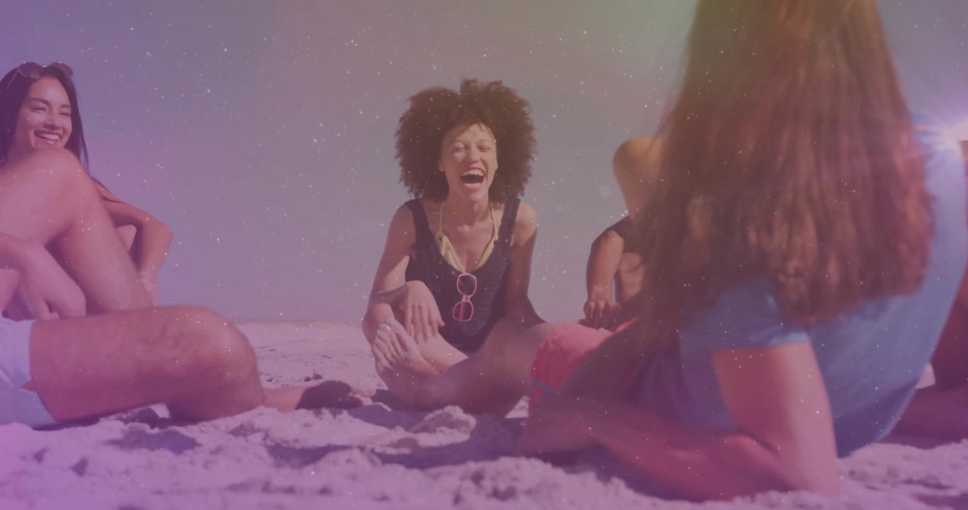 Amici seduti in cerchio sulla spiaggia che si passano occhiali da sole rosa, scatenando risate per il marketing lifestyle.
