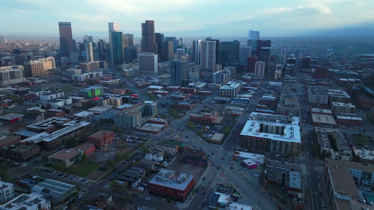 Rhino Downtown Denver cityscape city tall skyscraper buildings aerial drone Colorado spring summer afternoon sunset mountains range landscape stormy clouds sunny panorama forward pan up motion