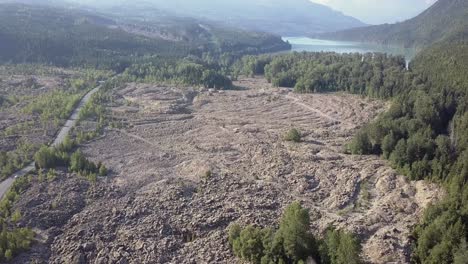 aerial: lone white car drives through volcanic lava bed, nature geology