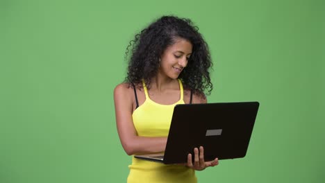 young beautiful hispanic woman thinking while using laptop
