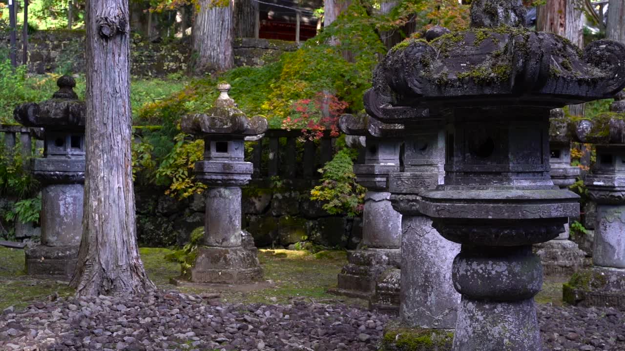 hermosos pilares de piedra japoneses dentro del santuario japonés durante los colores del otoño