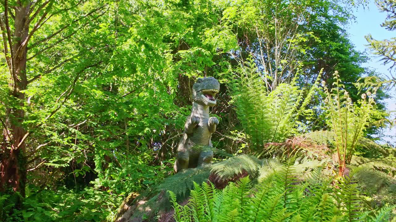 Lush botanical garden area at Upper Brittany Botanical Park with ferns and T. rex, Brittany, France.