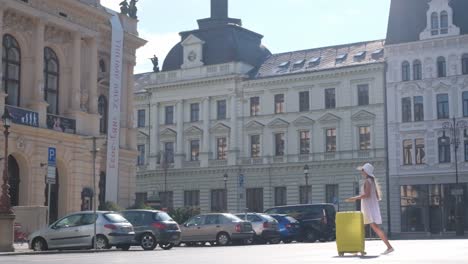 a girl tourist walks with a suitcase on wheels in the middle of an old european city. tourist trips