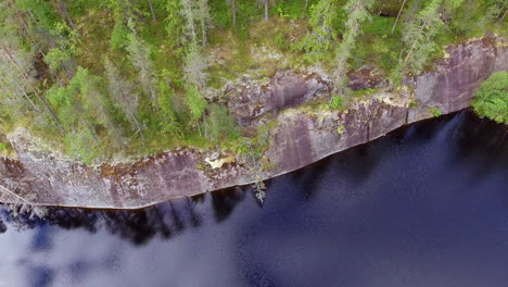 drone shot of a water polished steep cliff in the boreal wilderness