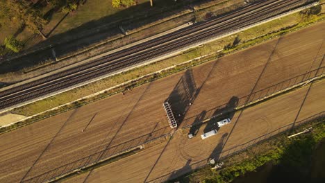 Horses-getting-into-position-on-the-race-track-during-sunset,-aerial-tilting