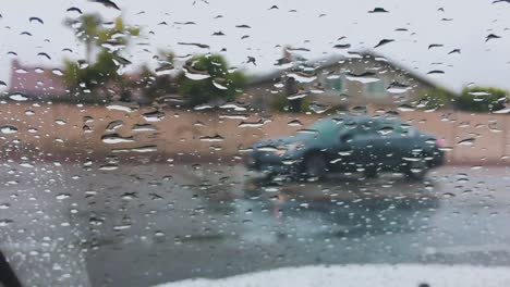 raindrops on car windshield while driving, closeup