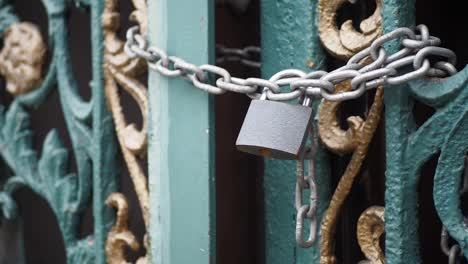 a locked metal gate with a chain and padlock