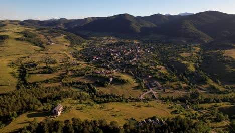 Bergdorf-Voskopoja-Zur-Goldenen-Stunde-Der-Dämmerung,-Umgeben-Von-Grünen-Wiesen-Und-Pinienwäldern