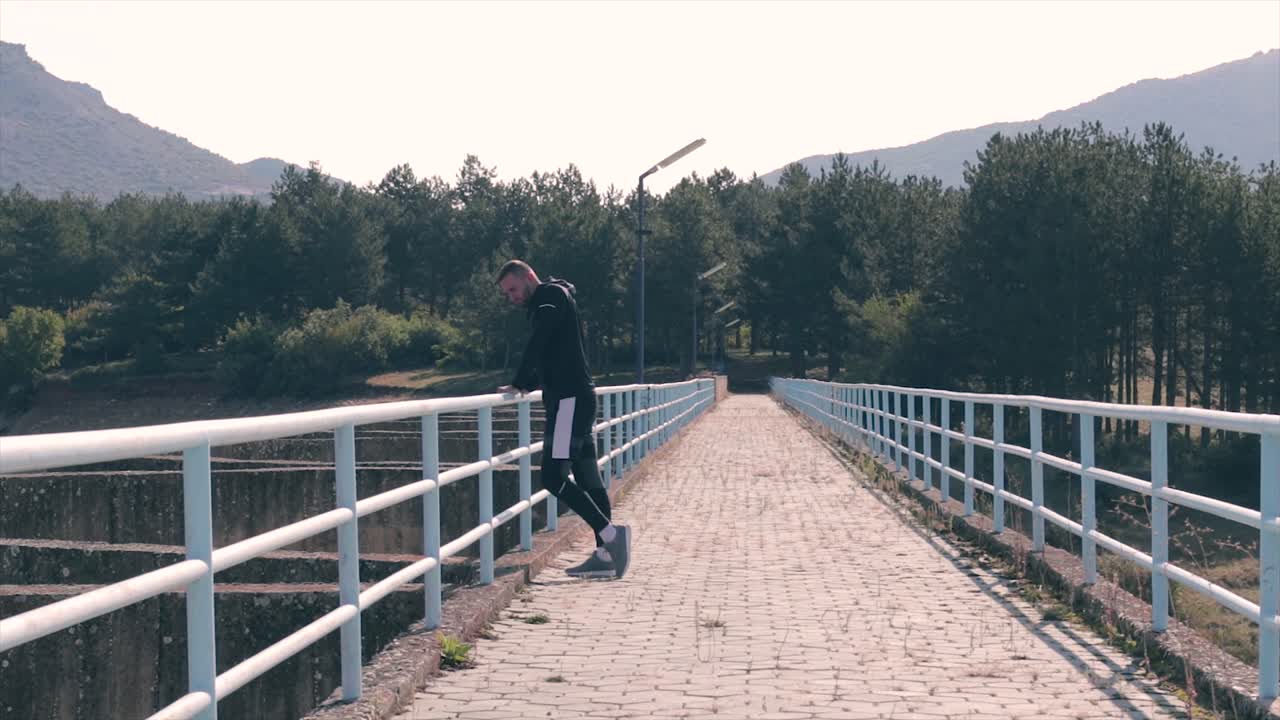 아름다운 녹색 자연을 관광하는 댐 위를 걷는 남자