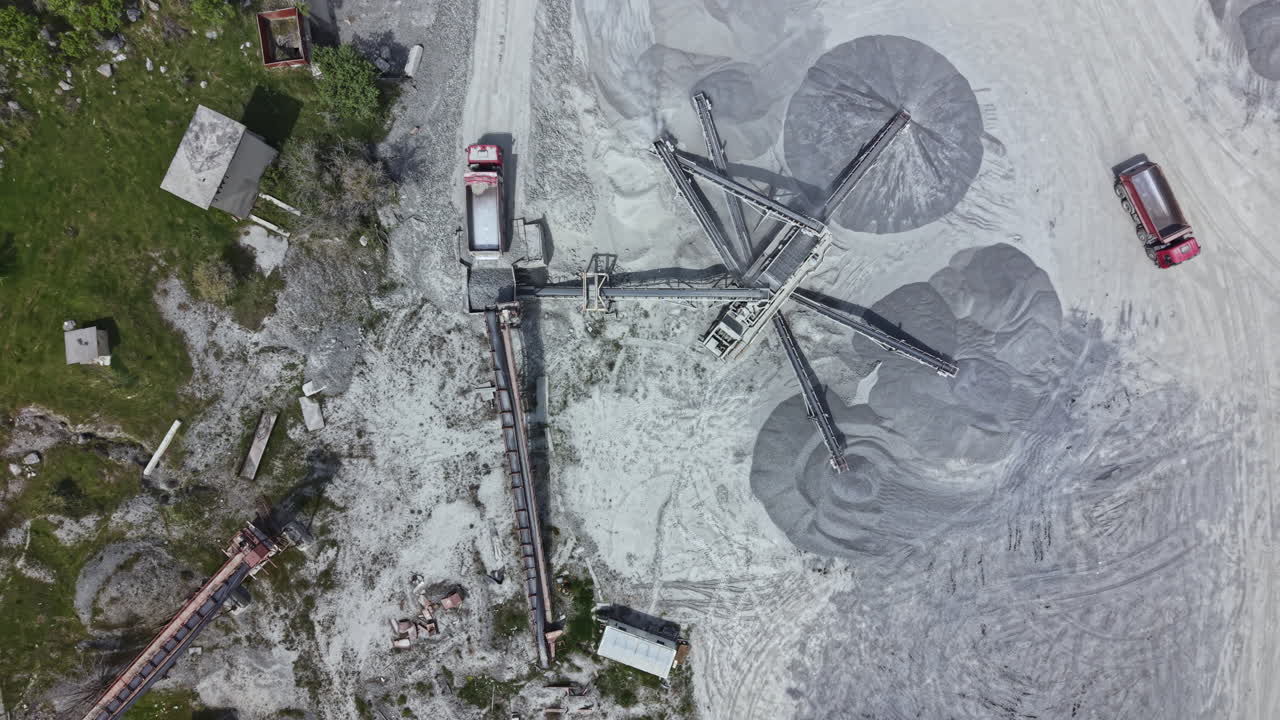 Large construction site with machinery working on gravel processing in a remote location during daylight hours