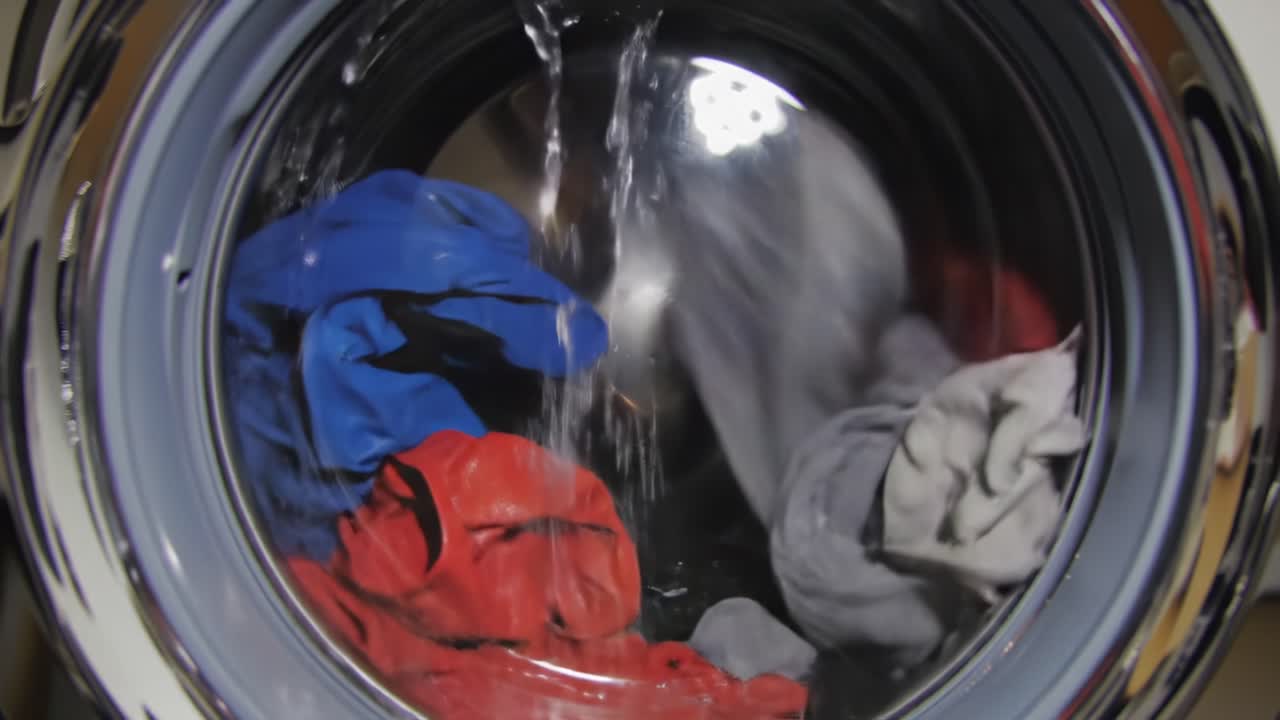 A Colorful Collection of Clothes Twirls in a Washing Machine, Highlighting the Dynamic Movement of Fabrics as Water Refreshes and Cleans Each Item with Care