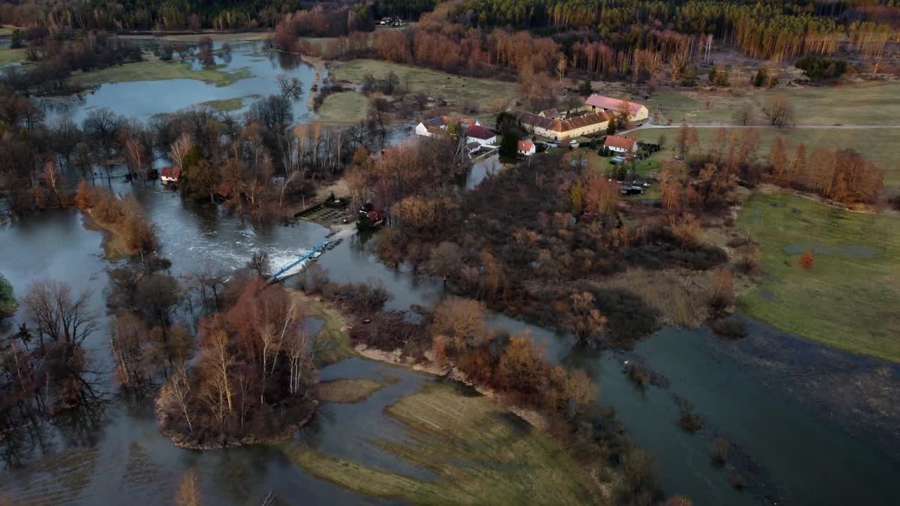 un río desbordado, una inundación, una granja cercana