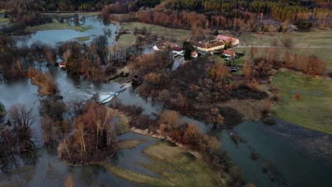 An-overflowing-river,-a-flood,-a-nearby-farm