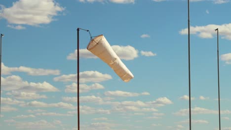 a white windsock blows in the breeze on a sunny day