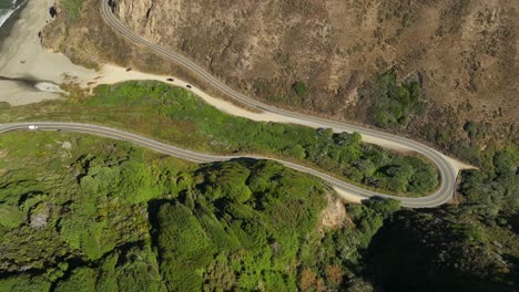 Rising-drone-shot-of-cars-driving-on-the-scenic-Pacific-Coast-Highway-in-Northern-California