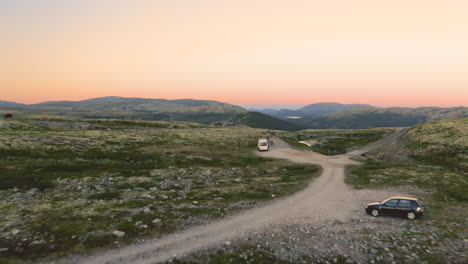 Autocaravana-Y-Autos-Descansando-En-La-Meseta-De-La-Montaña-Con-Un-Colorido-Fondo-De-Puesta-De-Sol-En-El-Parque-Nacional-De-Rondane,-Noruega