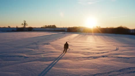 Die-Person-Genießt-Das-Eislaufen-Auf-Einem-Zugefrorenen-Teich-Auf-Dem-Land-Während-Des-Wintersonnenuntergangs