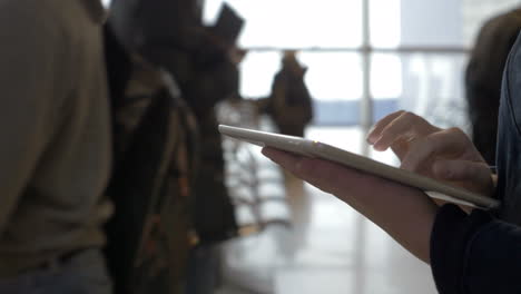 walking with tablet computer in airport lounge