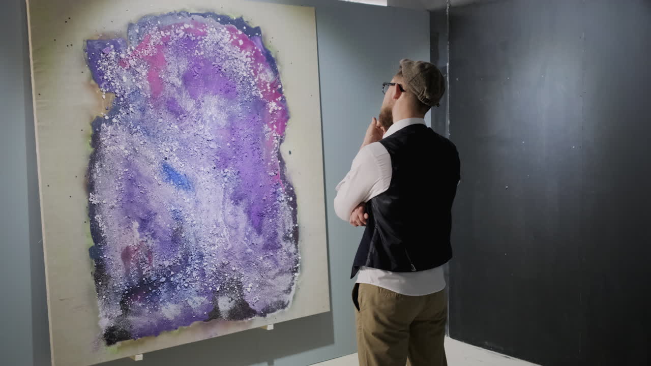 갤러리에서 추상적인 그림을 보는 남자