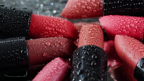 close-up of various shades of lipstick with water droplets