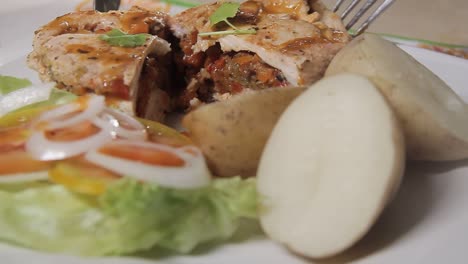 primer plano de chef cortando pollo con verduras en plato blanco, concepto de cocina casera saludable