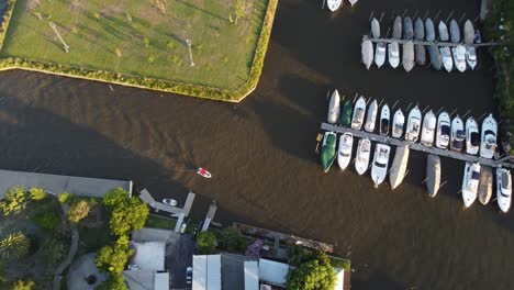 An-orbiting-aerial-shot-of-a-sail-boat-arriving-at-the-yacht-club-in-Náutico-San-Isidro,-Buenos-Aires