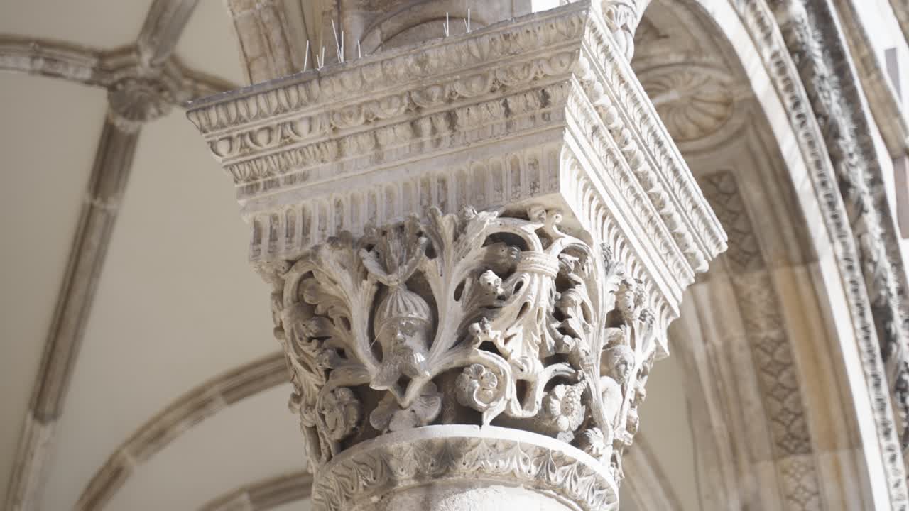 Close up of filigree worked ornamented historical medieval details on the pillars in front of the Palace Grade in Old Town Dubrovnik Croatia on a sunny summer day within the stronghold