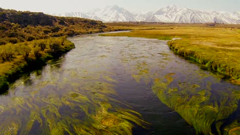 La-Cámara-Se-Mueve-A-Través-De-Un-Puente-Para-Revelar-Un-Hermoso-Río-Sierra-Y-Montañas-De-Fondo