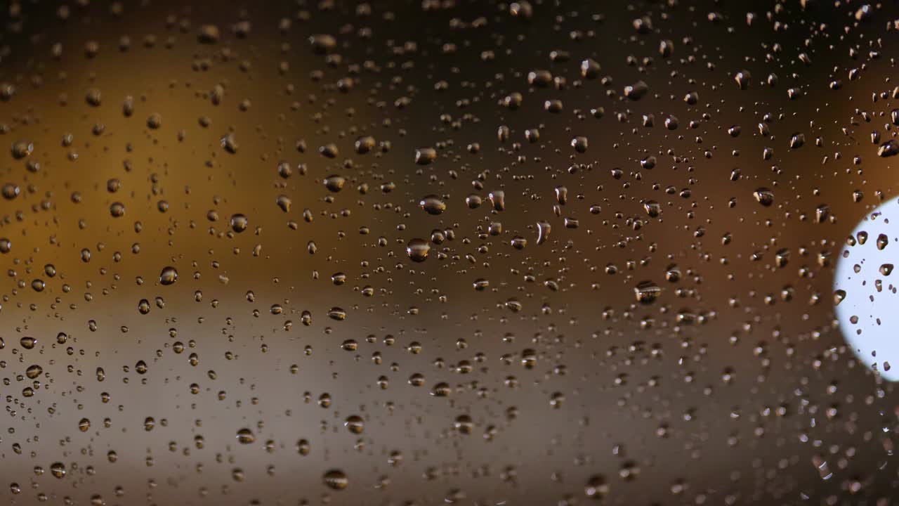 vista abstracta de los coches que pasan por la ciudad por la noche. vista a través de vidrio húmedo. tráfico nocturno de la ciudad, día lluvioso