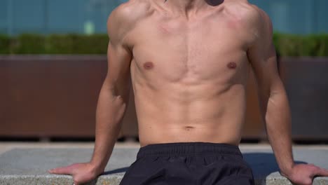 shirtless muscular young sportsman exercising outdoor