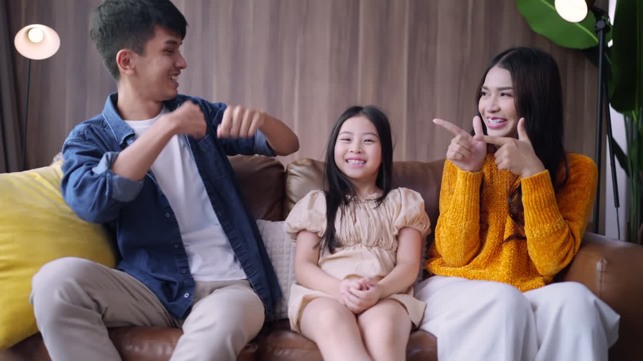 재미있고 즐거운 출발 순간 아시아 가족 부모와 딸은 함께 온라인 스트리밍 콘서트를보고 소파 소파에 함께 집에서 거실에서 행복 가족 춤 움직이는 손 기쁜