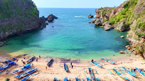 Exotic fishing village with blue boats in Indonesia, aerial view