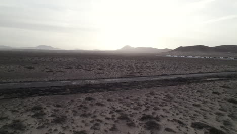 Flying-over-Lanazrote-desert,-volcanos-in-the-horizon