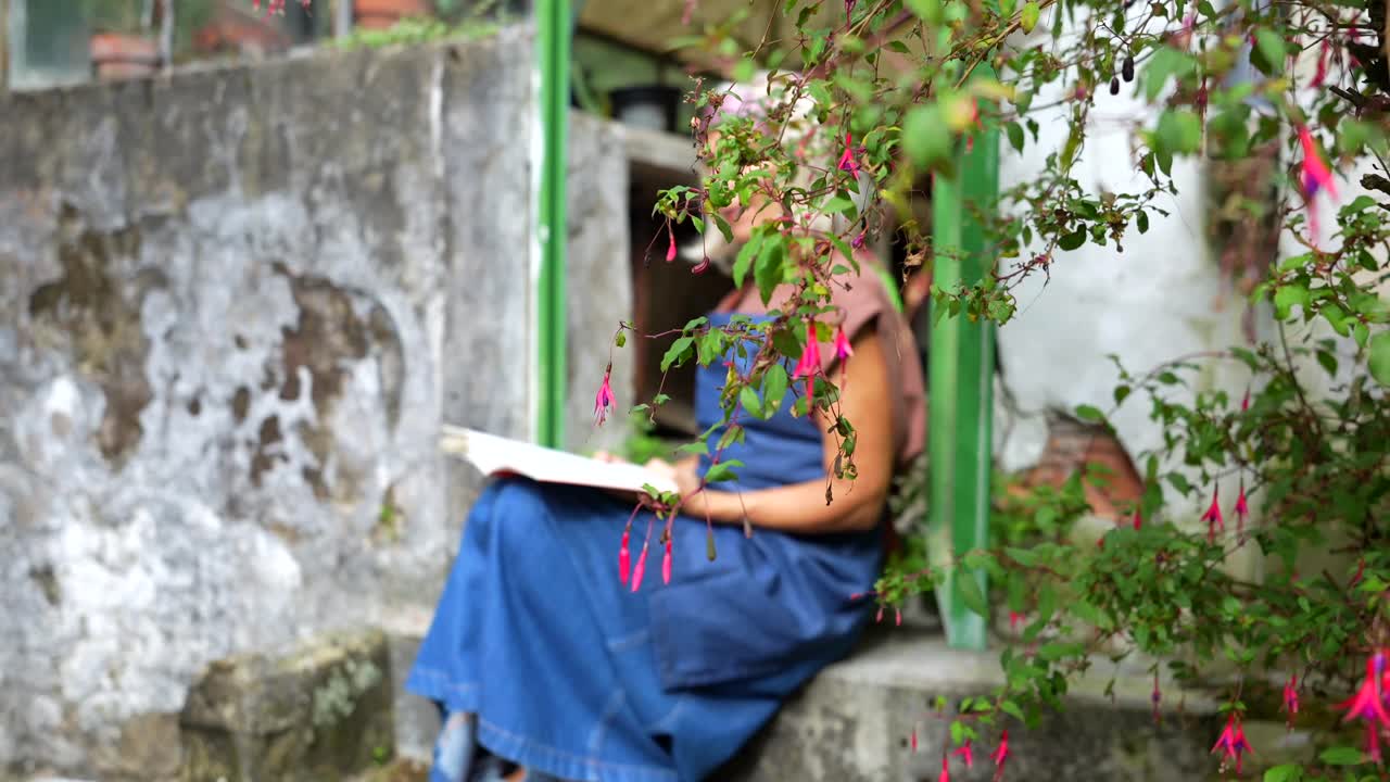Woman Reading a Book in a Greenhouse Doorway