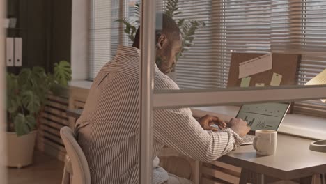 african-american man working on laptop in evening