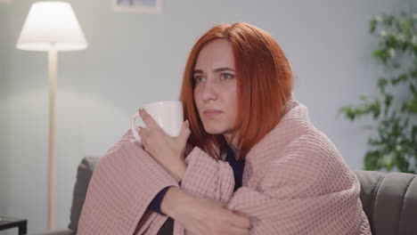 Focused-woman-with-ginger-hair-watches-exciting-TV-show