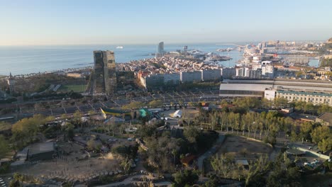 drone flying above ciutadella park in barcelona, spain toward coastline