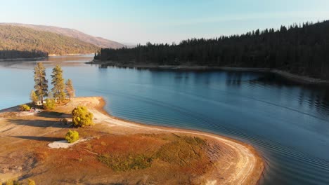 Aerial-shot-of-an-island-in-a-alpine-lake-during-magic-hour