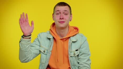 man teenager smiling friendly at camera and waving hands gesturing hello or goodbye, welcoming