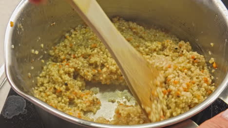 couscous dish cooking in pot, low heat, steamed granules of rolled semolina