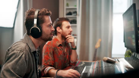 two men working on sound mixing in a music studio