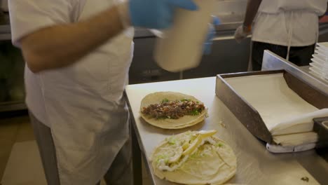 Chef-Preparing-Hot-Philadelphia-Meat-Sandwich-In-Kitchen