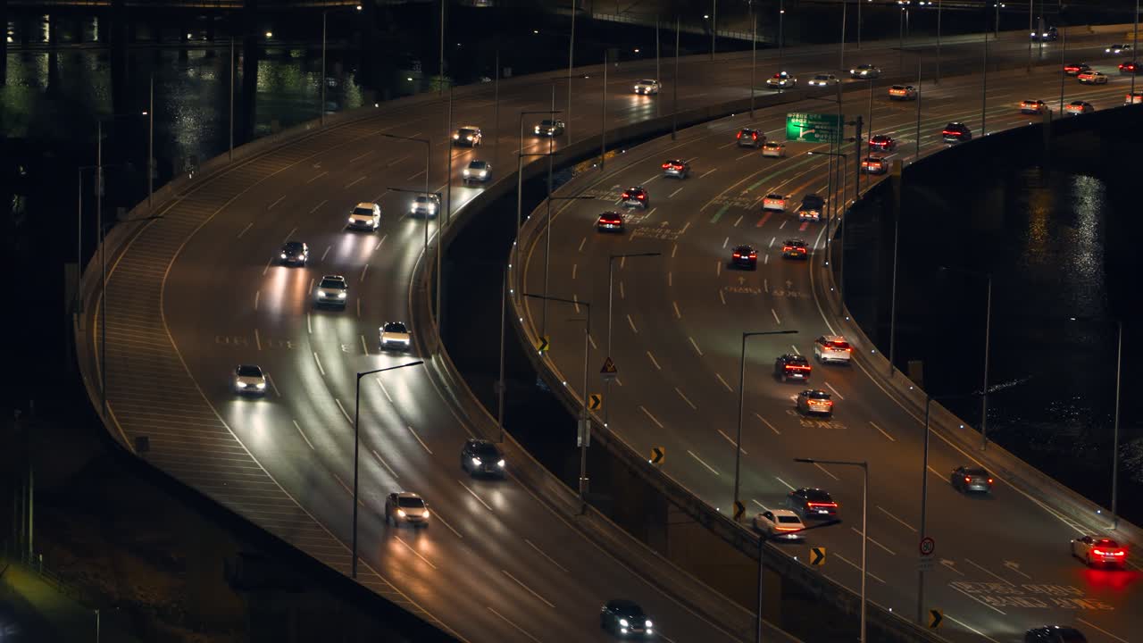 Luftfoto av travel biltrafikk med glødende frontlykter på buet Gangbyeonbuk-ro motorveibro over Han-elven om natten i Seoul, Sør-Korea